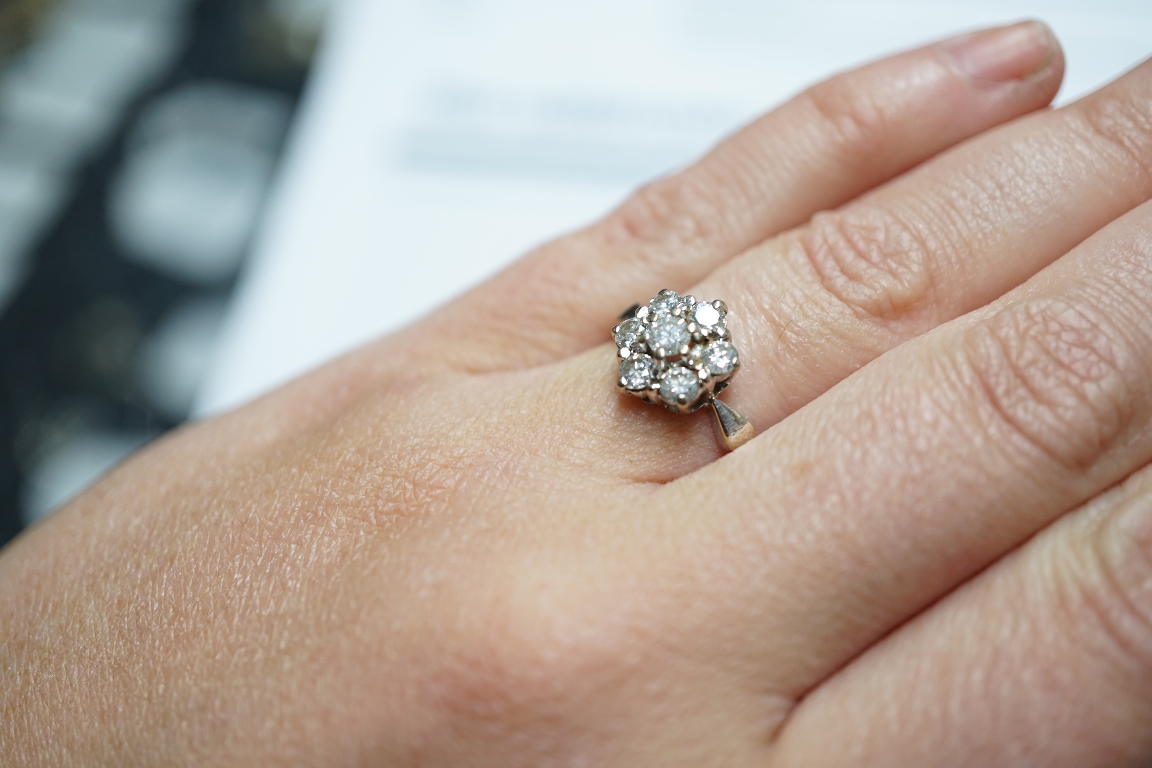 A modern 18ct white gold and seven stone diamond set hexagonal cluster ring, size O, gross weight 3.9 grams.